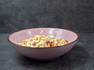 Muesli in a cup on a gray table.