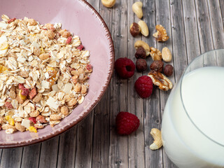 Muesli in a cup and a glass of milk on a wooden table. Muesli on a wooden background.