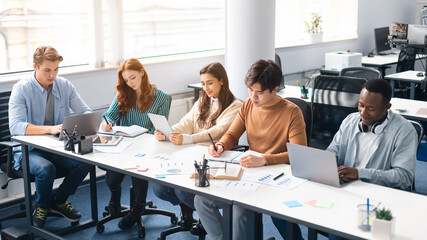 Group of international people studying together in classroom