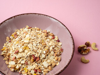 Muesli in a pink cup on a pink table. Muesli on a pink background.