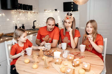 A family in red T-shirts celebrating Christmas in the kitchen