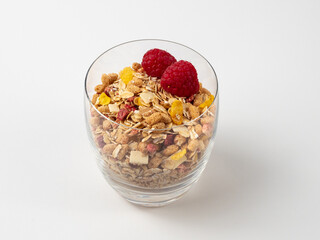 Muesli in a glass glass and berries on a white table. Muesli isolated on a white background.