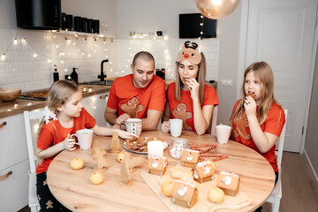 A family in red T-shirts celebrating Christmas in the kitchen