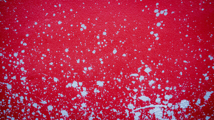 Red cement wall with splash marks, scattered mortar, used as a background or wallpaper.