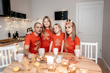 A family in red T-shirts celebrating Christmas in the kitchen