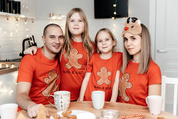 A family in red T-shirts celebrating Christmas in the kitchen