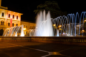 Illuminated and colored fountain with the Cattolica town hall in the background