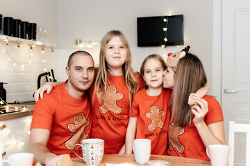 A family in red T-shirts celebrating Christmas in the kitchen