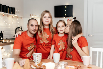 A family in red T-shirts celebrating Christmas in the kitchen