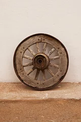 Fotobehang Isolated old wooden wagon wheel leaning against a white wall © Angela