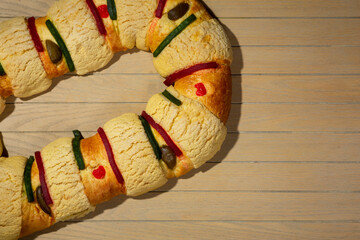 delicious rosca de reyes on wooden table, rosca de reyes ready to eat served in an artisanal plate with hot chocolate drink.