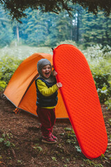Family camping child with sleeping pad and tent gear travel adventure vacations hiking equipment...