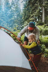Child helps father to set camping tent travel family vacations hiking outdoor adventure lifestyle backpacking trip in forest - 478838624