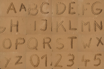 buchstaben zahlen und zeichen im sand