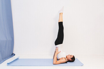 Young woman in yoga class doing shoulder stand