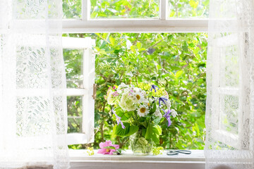 Bouquet of garden flowers on opened window