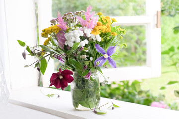 Bouquet of garden flowers on opened window