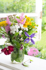 Bouquet of garden flowers on opened window