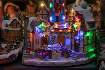 Toy Christmas village with colorful illumination and moving figures.