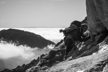 chica en la montaña con una mochila y mar de nubes de fondo