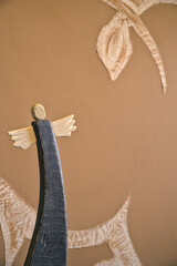 wooden painted angel on abstract blurry background, old handicraft figurines, background with winding motif with free space for text, beautiful angels in folk minimal style for wallpaper 