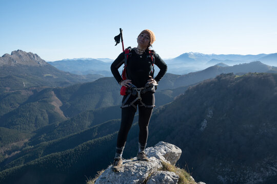 chica en la monta&ntilde;a con una mochila y mar de nubes de fondo