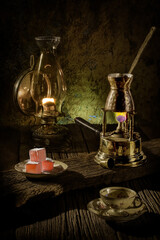 Traditional coffee in vintage cup with alcohol stove and Turkish delights.
Wooden table and oil lamp. Cookies and a box of sugar and coffee.