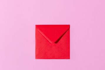 Top view of a red envelope on pastel pink and lavender copy space background. Valentines, love letter, message concept.
