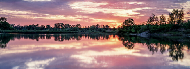 Clouds are reflected in the lake at sunset