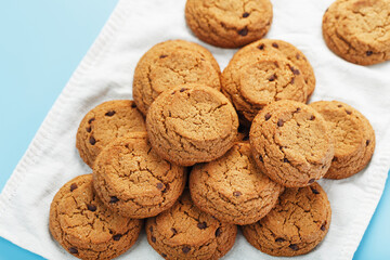 Oatmeal cookies on a blue background and a white napkin top view