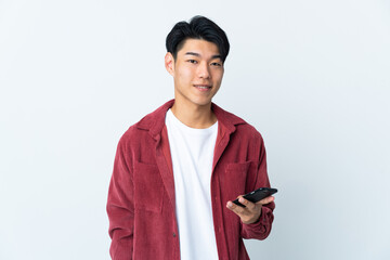 Young Chinese man isolated on white background using mobile phone