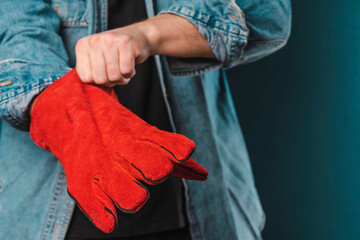 worker wears red leather protective gloves. Protective gloves for working men. gloves for the iron...