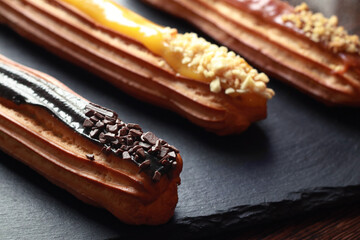 Tasty eclairs with different tastes, close up            
