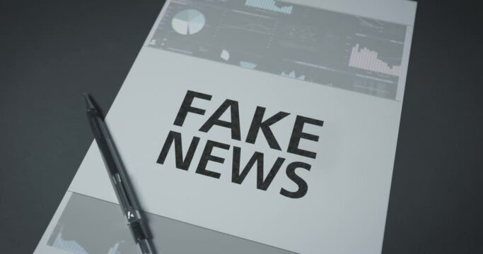 Fake News headline digital on sheet of paper with pen on desk