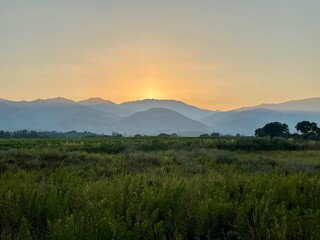 Obraz premium Fertile east coast with mountain ridge in the background at sunset. Corsica, France.