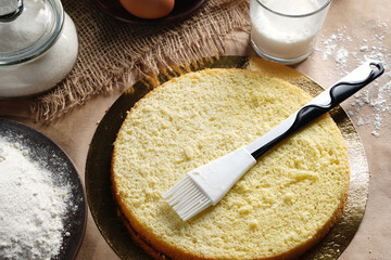 Preparing and impregnation with a milk of biscuit with a silicone brush. Baking a sponge biscuit...