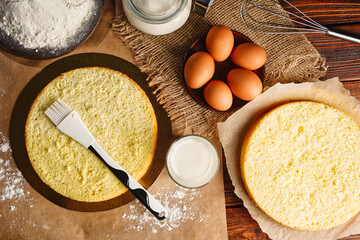 Flat lay impregnation with a milk of biscuit with a silicone brush. Baking a sponge biscuit cake....