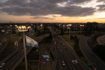 Toma aerea de autopista al atardecer con bander argentina - obrazy, fototapety, plakaty