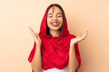 Young Indian woman isolated on beige background smiling a lot