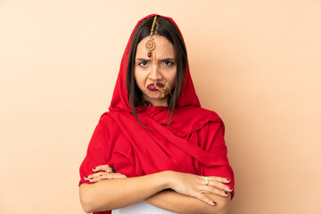 Young Indian woman isolated on beige background with unhappy expression