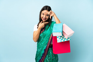 Young Indian woman with shopping bags focusing face. Framing symbol