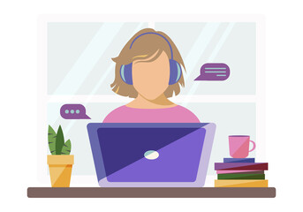 A woman wearing headphones works remotely from home with a laptop during quarantine due to coronavirus. Stay at home. Getting an education online. Communication with family via the Internet. 