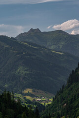 Summer valley with Grossarler Ache small river and blue cloudy sky