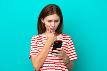 Young English woman isolated on blue background thinking and sending a message