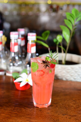 Tropical red fruit drink served in an exotic glass with dehydrated fruits and ice