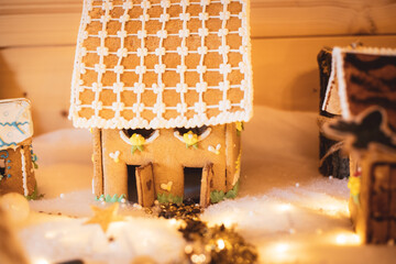 Little gingerbread house with glaze on snow and decorations. Christmas holiday mood.