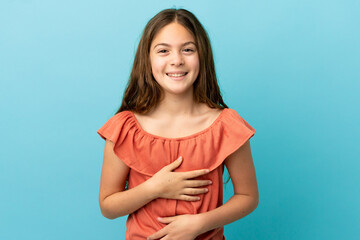 Obraz premium Little caucasian girl isolated on blue background smiling a lot