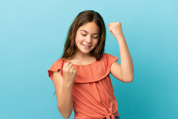 Little caucasian girl isolated on blue background celebrating a victory