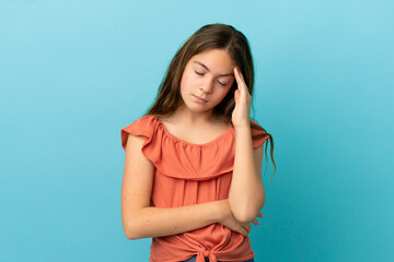 Little caucasian girl isolated on blue background with headache