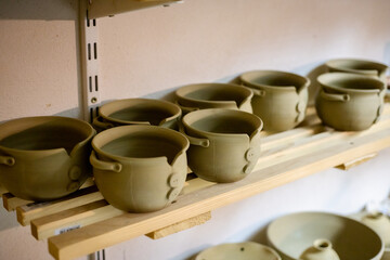 Selective focus of clay pots at table in pottery studio